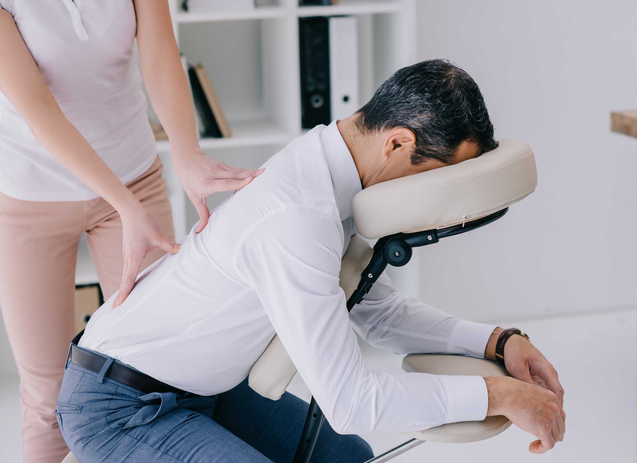 homme recevant le massage assis sur une chaise ergonomique